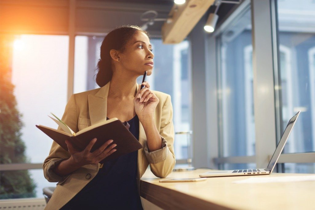 Woman holding a note book thinking