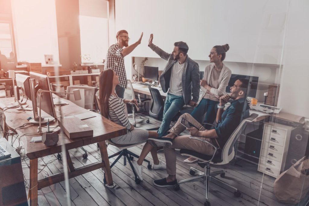 team of employees cheering in office