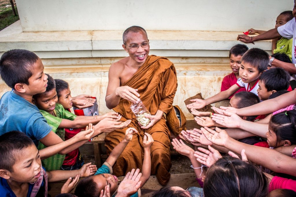 monk giving food to children