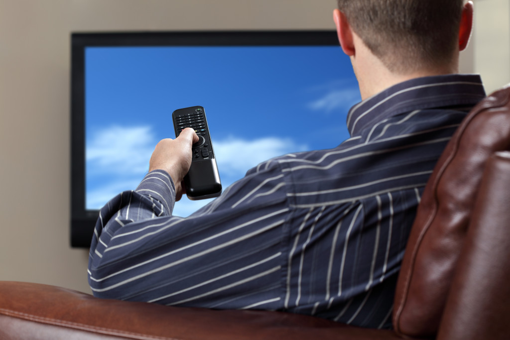 person siting on a couch, watching tv