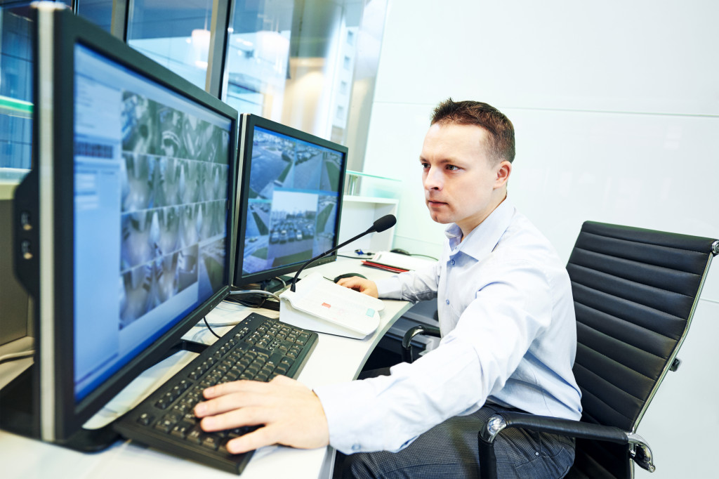 a guard watching security cameras