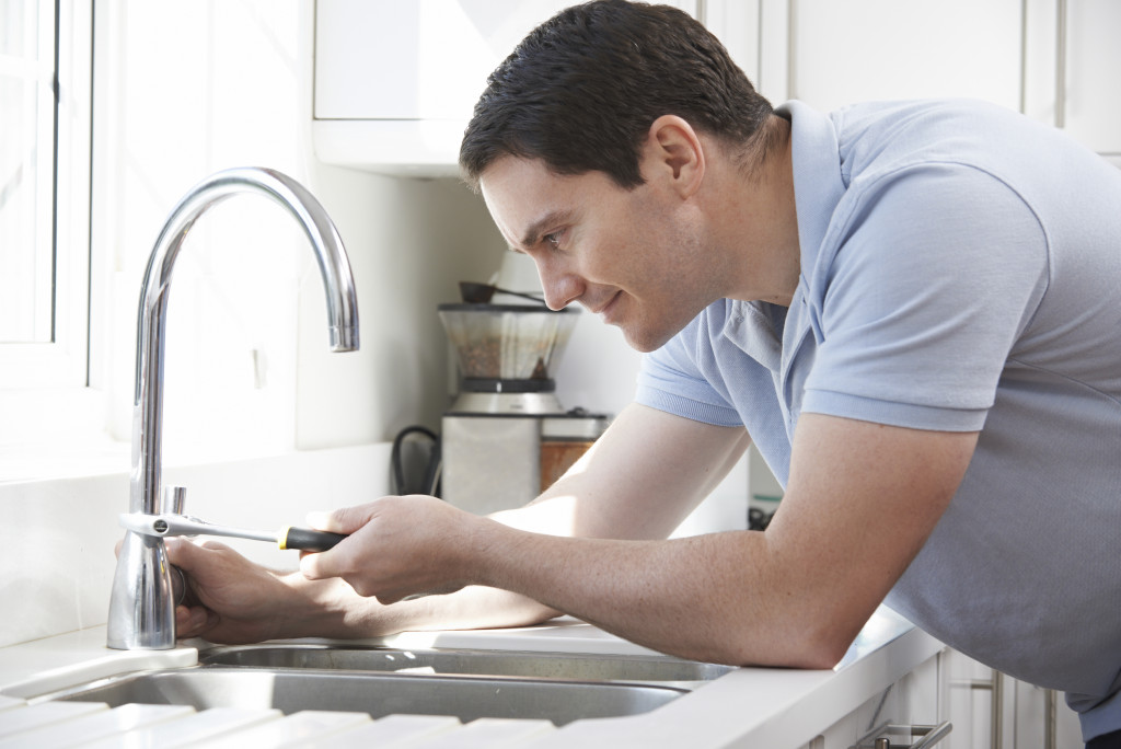 man fixing faucet