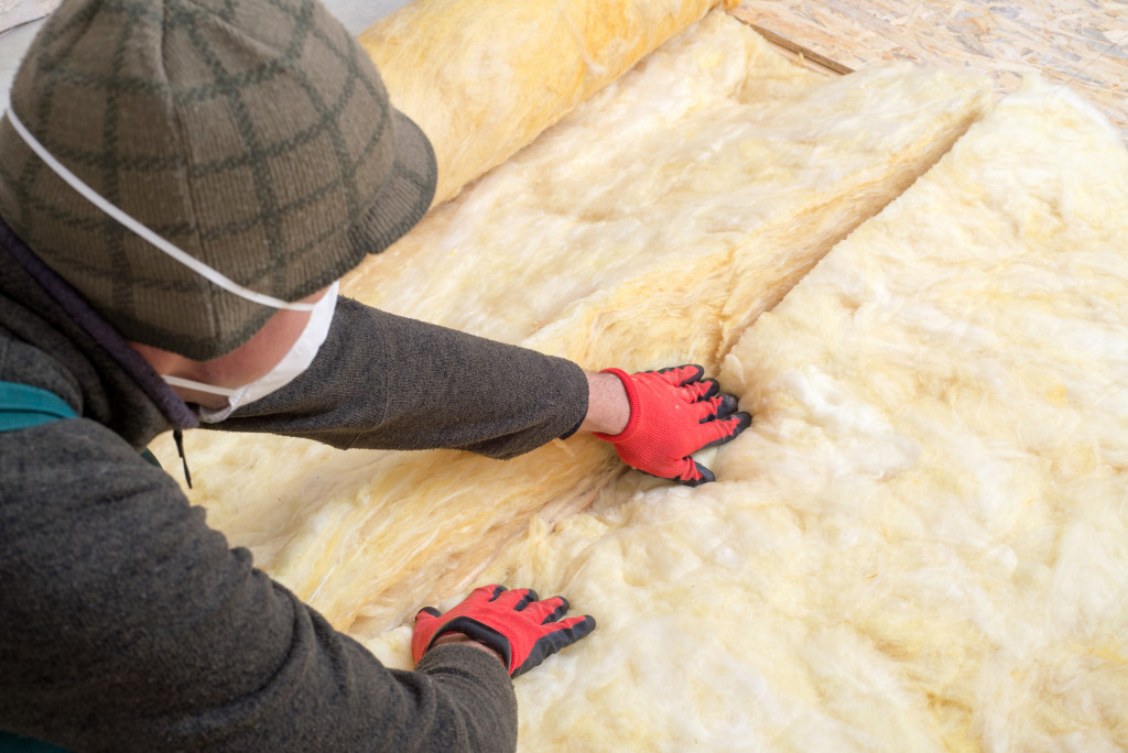 Worker installing insulation in a house.