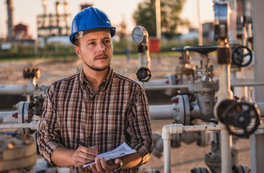 man checking manometer in gas holding a report