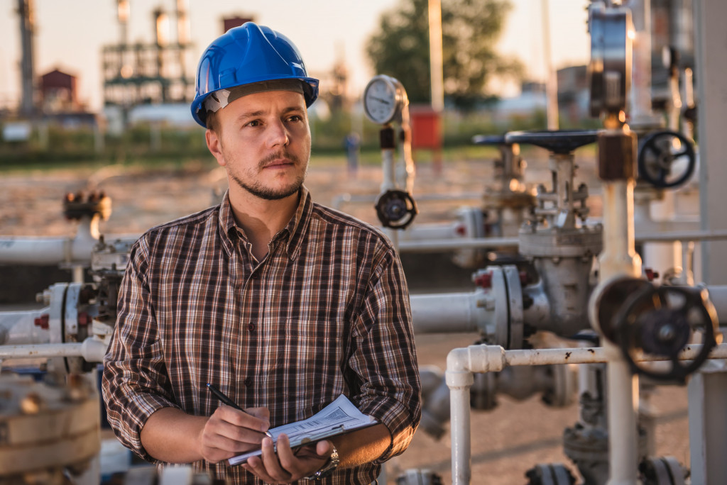 man checking manometer in gas holding a report