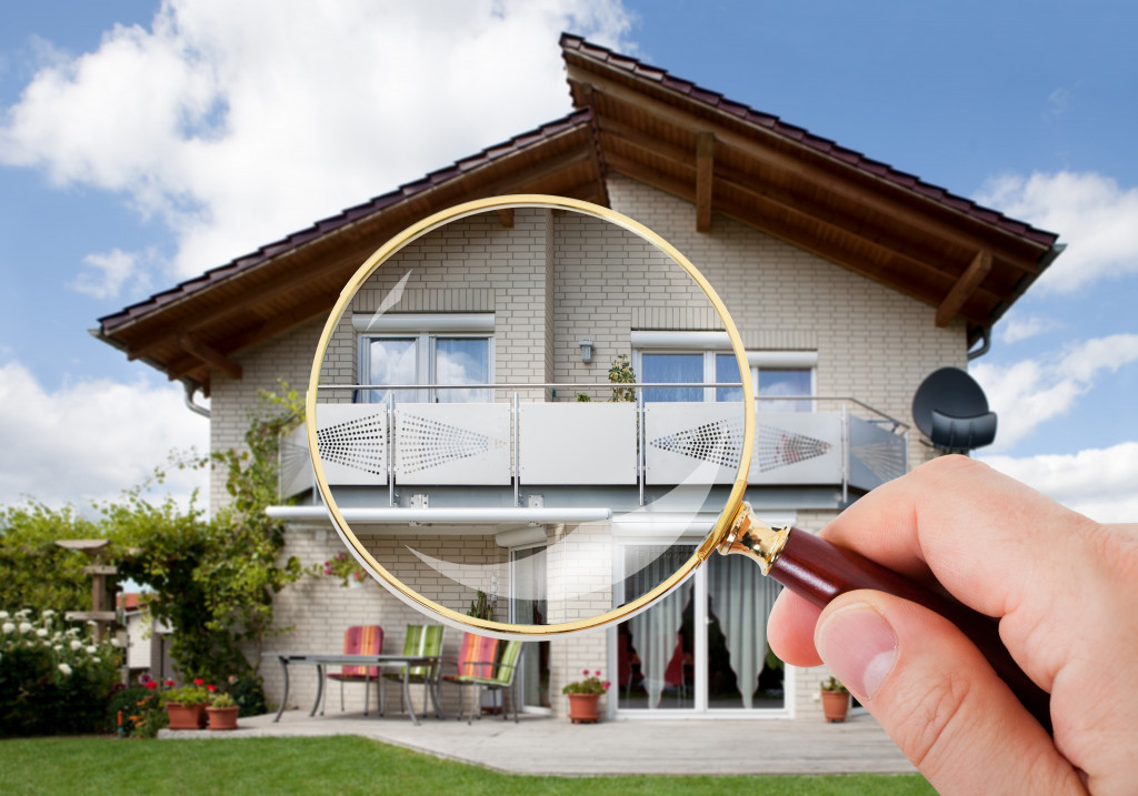 person with magnifying glass on luxury suburban house